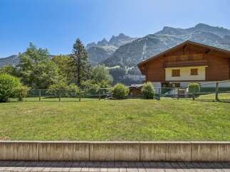 Nestled against a backdrop of majestic mountains, this charming wooden chalet offers a serene retreat.
