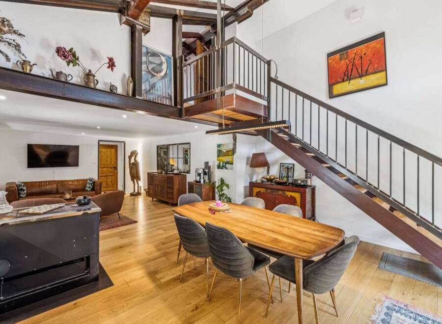 Experience industrial-chic living in this stunning open-concept space, featuring exposed steel beams and a dramatic spiral staircase.