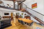 Experience industrial-chic living in this stunning open-concept space, featuring exposed steel beams and a dramatic spiral staircase.