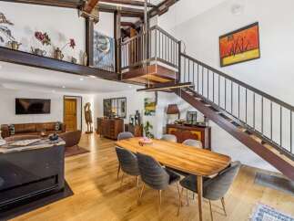 Experience industrial-chic living in this stunning open-concept space, featuring exposed steel beams and a dramatic spiral staircase.