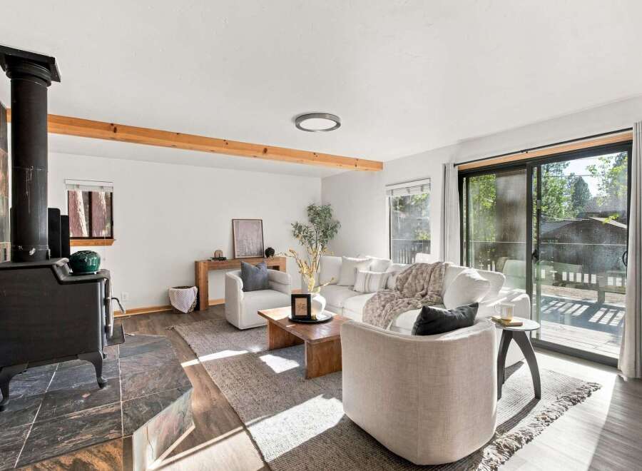 Cozy living room featuring a modern wood-burning stove and exposed wooden beams, creating a rustic yet contemporary ambiance.