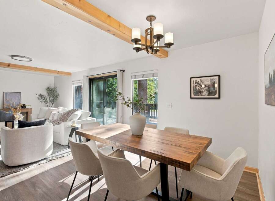 Experience modern living in this beautifully appointed dining area, featuring a rustic wooden dining table complemented by comfortable upholstered chairs.