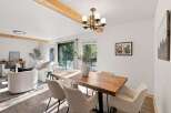 Experience modern living in this beautifully appointed dining area, featuring a rustic wooden dining table complemented by comfortable upholstered chairs.