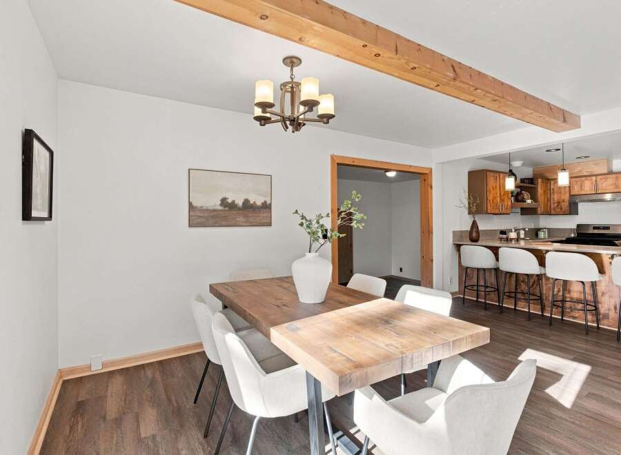 Experience the perfect blend of rustic charm and modern comfort in this inviting dining area, featuring a substantial wooden table and plush seating.