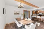 Experience the perfect blend of rustic charm and modern comfort in this inviting dining area, featuring a substantial wooden table and plush seating.