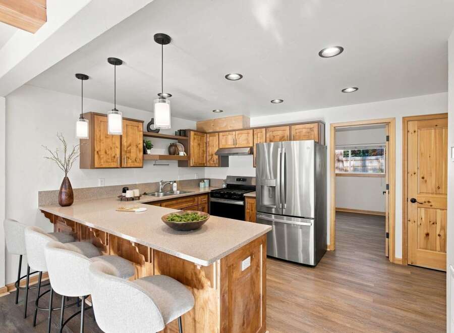 Discover this charming kitchen featuring warm wooden cabinetry and a spacious island with seating, perfect for casual dining.