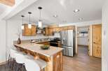 Discover this charming kitchen featuring warm wooden cabinetry and a spacious island with seating, perfect for casual dining.