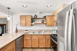 Discover this charming kitchen featuring warm, natural wood cabinetry and sleek stainless steel appliances, including a modern refrigerator and dishwasher.