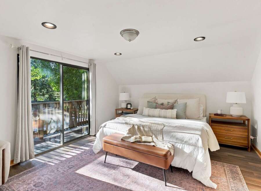 Experience serene living in this charming bedroom, featuring a comfortable queen-size bed adorned with plush pillows and a cozy throw.