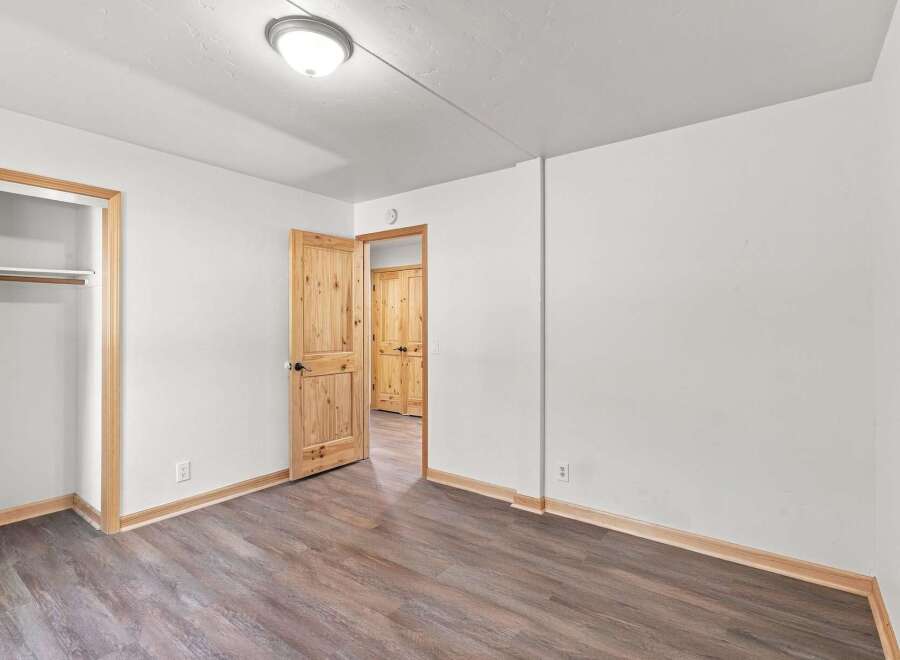 Step into this inviting bedroom featuring a spacious closet and beautiful wooden doors that add a touch of rustic charm.
