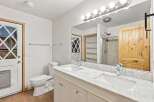 This bright and airy bathroom features a double vanity with a marble countertop, offering ample space for toiletries and morning routines.