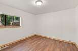 This inviting room features a large window offering picturesque views of the surrounding trees and a charming fence.