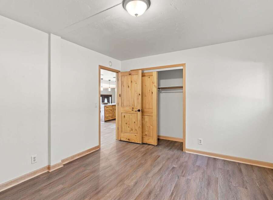 Discover this charming bedroom featuring a spacious closet with elegant wooden sliding doors, perfect for maximizing space.
