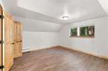 Discover this charming room featuring rustic wooden doors and a large window offering serene forest views.