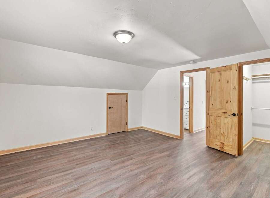 Discover this charming bedroom featuring a vaulted ceiling and a spacious walk-in closet, perfect for ample storage.