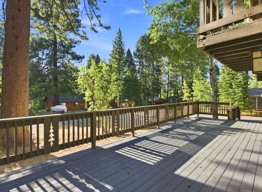 Enjoy the serene mountain lifestyle from this spacious deck, perfect for outdoor entertaining or quiet relaxation amidst towering trees.
