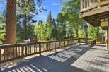 Enjoy the serene mountain lifestyle from this spacious deck, perfect for outdoor entertaining or quiet relaxation amidst towering trees.