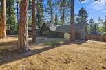 Nestled among tall pine trees, this charming home offers a serene retreat.