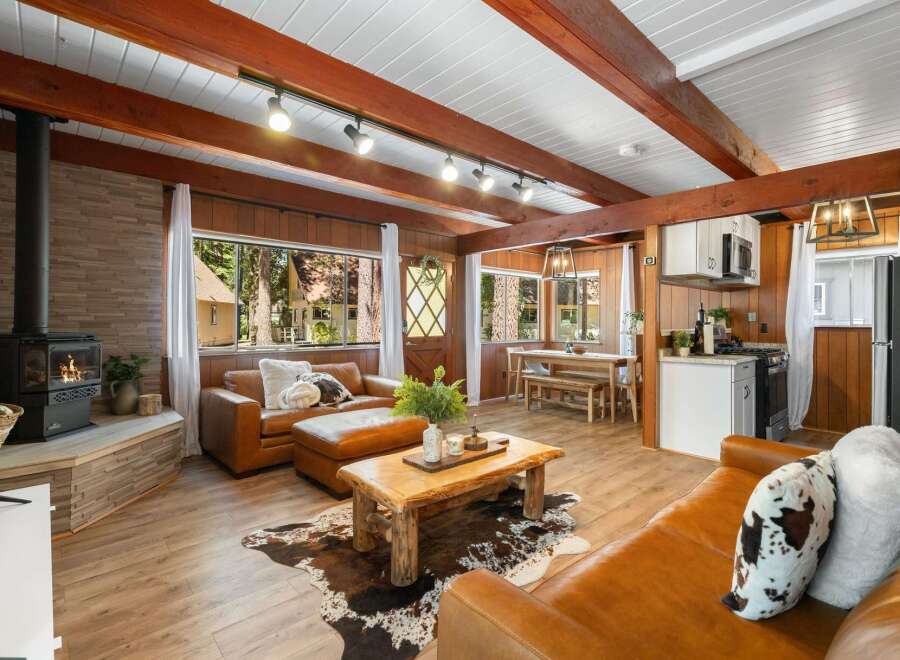 Experience rustic charm in this cozy living area featuring a wood-burning stove and rich wood paneling.