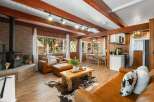 Experience rustic charm in this cozy living area featuring a wood-burning stove and rich wood paneling.