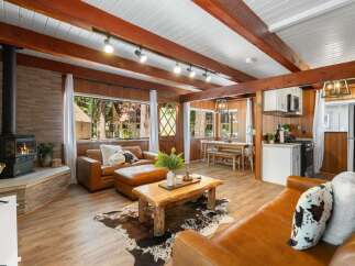 Experience rustic charm in this cozy living area featuring a wood-burning stove and rich wood paneling.
