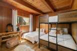 This charming cabin bedroom features a cozy bunk bed setup and a separate twin bed, perfect for accommodating family or guests.