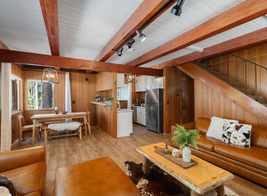 Experience rustic charm in this inviting living space featuring warm wood paneling and exposed beams.