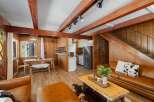 Experience rustic charm in this inviting living space featuring warm wood paneling and exposed beams.