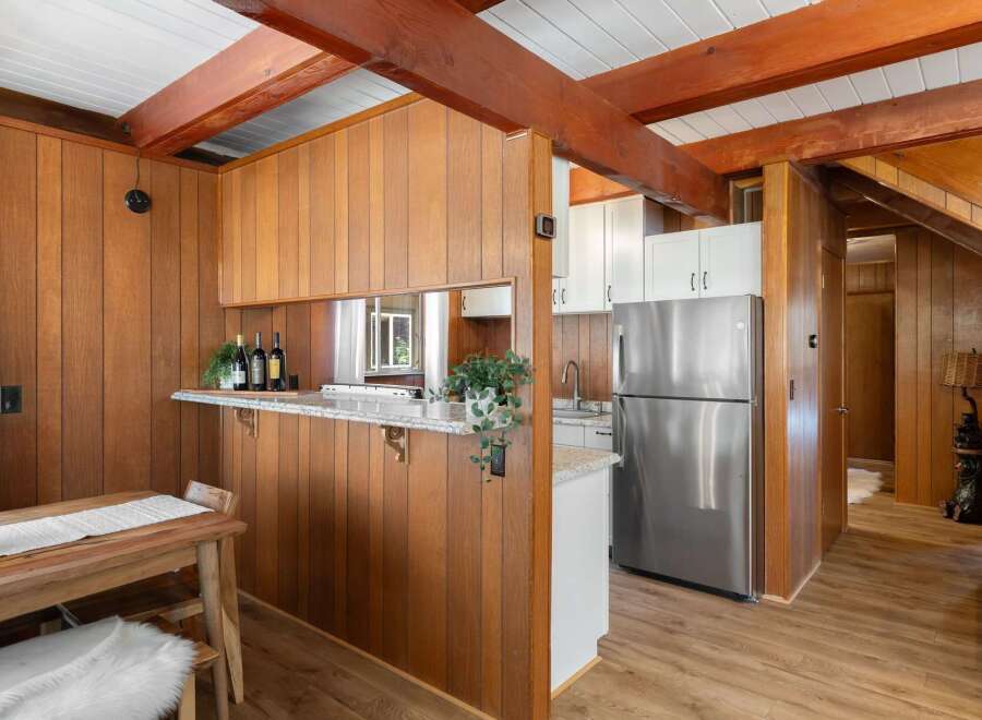 Step into a charming kitchen featuring warm wood paneling and exposed beams, creating a cozy and rustic ambiance.