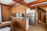 Step into a charming kitchen featuring warm wood paneling and exposed beams, creating a cozy and rustic ambiance.