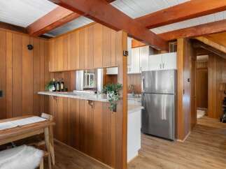 Step into a charming kitchen featuring warm wood paneling and exposed beams, creating a cozy and rustic ambiance.