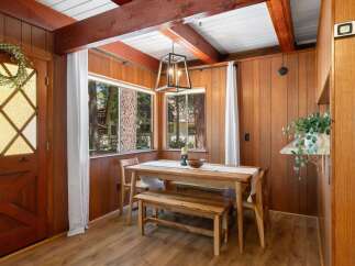 Experience cozy dining in this charming space featuring a rustic wooden dining table and bench, perfect for intimate meals.