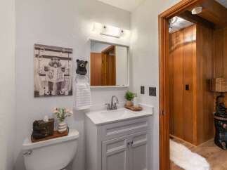 This charming bathroom features a whimsical bear-themed decor, including a playful wall art and a unique tissue box holder.