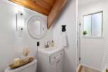 Charming bathroom featuring a white vanity with silver knobs, a round beaded mirror, and a unique black bear towel ring.