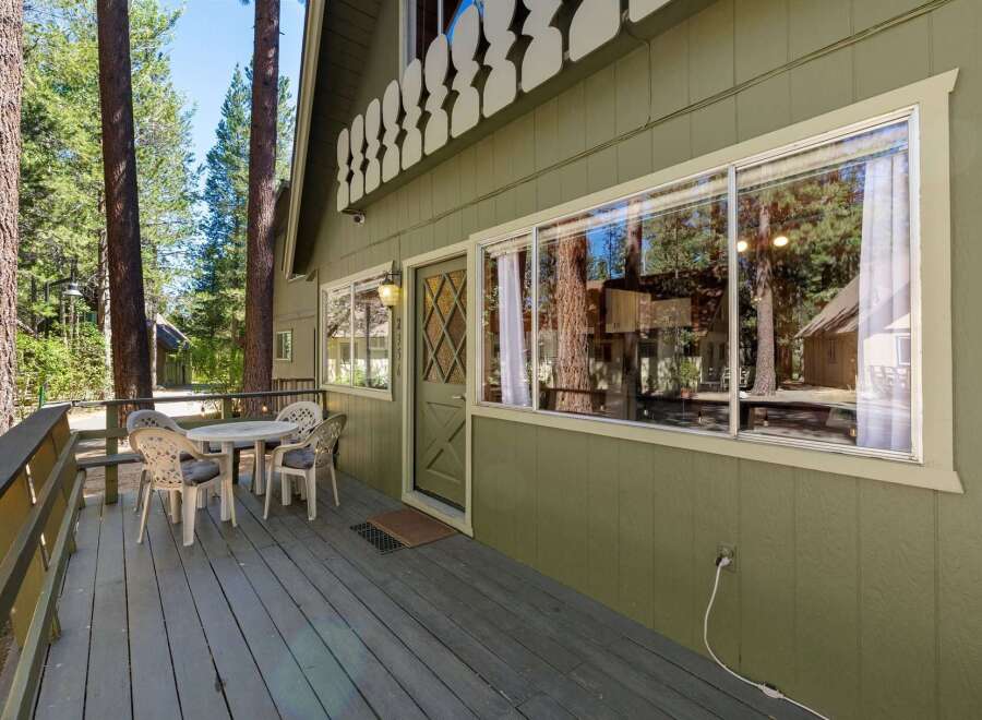 Enjoy the serene mountain setting from this charming cabin's spacious deck, perfect for morning coffee or evening relaxation.
