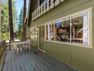 Enjoy the serene mountain setting from this charming cabin's spacious deck, perfect for morning coffee or evening relaxation.