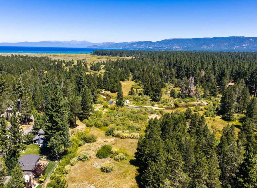 Experience the serene beauty of this expansive property, nestled amidst a lush pine forest with a meandering creek.