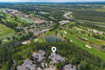 Experience luxury living with this stunning aerial view showcasing a magnificent estate nestled amidst a picturesque golf course and lush forest.