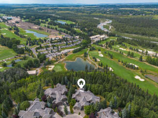 Experience luxury living with this stunning aerial view showcasing a magnificent estate nestled amidst a picturesque golf course and lush forest.