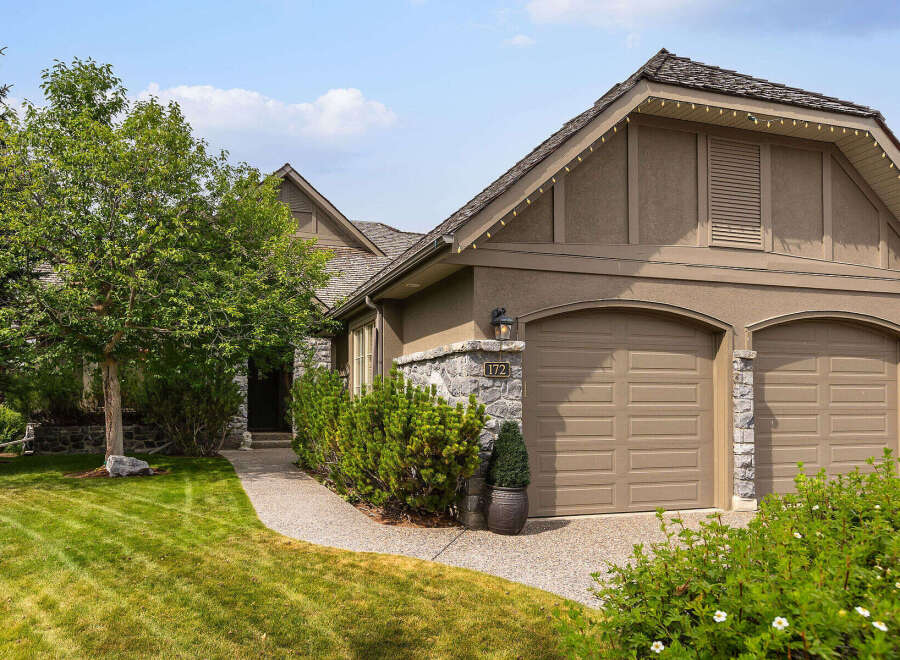 Discover this charming home featuring a welcoming stone-accented exterior and a well-maintained lawn.