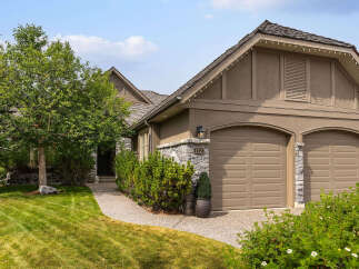 Discover this charming home featuring a welcoming stone-accented exterior and a well-maintained lawn.