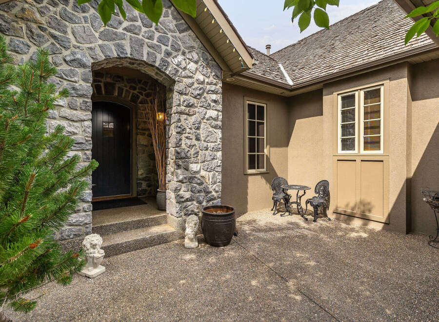 Step into this charming home through a grand stone archway leading to a welcoming front door.