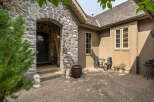 Step into this charming home through a grand stone archway leading to a welcoming front door.