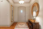 Step into a welcoming entryway featuring a charming arched door and a beautiful Persian rug.