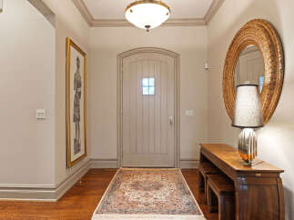 Step into a welcoming entryway featuring a charming arched door and a beautiful Persian rug.