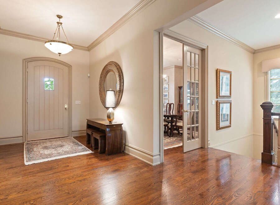 Step into a grand foyer featuring a beautiful arched front door and gleaming hardwood floors.