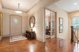 Step into a grand foyer featuring a beautiful arched front door and gleaming hardwood floors.