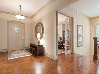 Step into a grand foyer featuring a beautiful arched front door and gleaming hardwood floors.