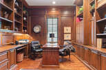 Step into this elegant home office, featuring rich mahogany built-in bookshelves and cabinetry that exude timeless sophistication.