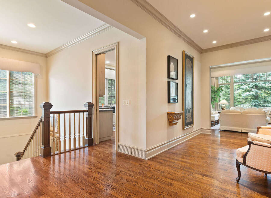 Step into this elegant home featuring a grand staircase and gleaming hardwood floors that lead to an open-concept living area.